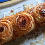 Sliced cheeseburger onion ring roll on wooden board