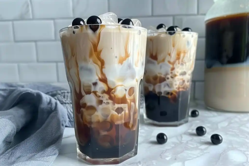 Hokkaido milk tea in a steaming glass with creamy froth